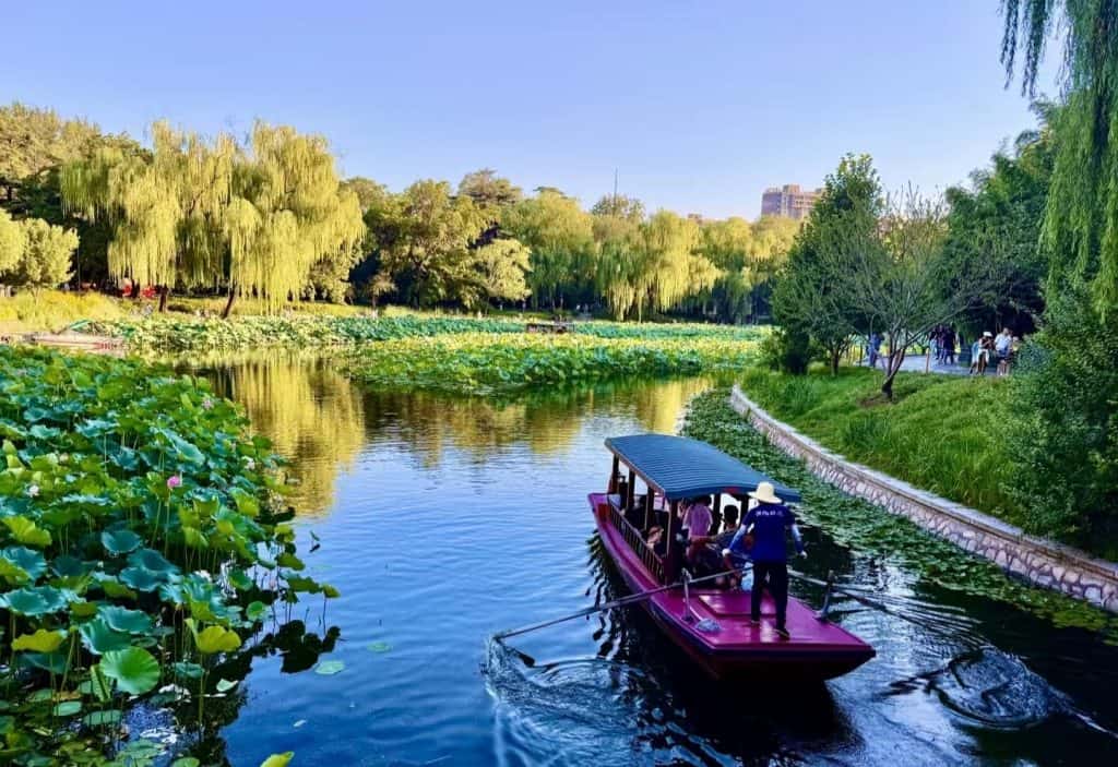 Tourists boating on calm water at Zizhuyuan Park, Beijing, China