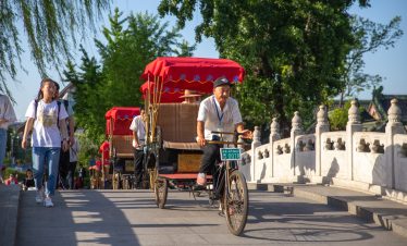 A group of rickshaws-driving through a bridge