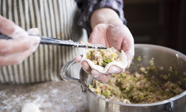 Tourist making wontons with local Shanghai family at home