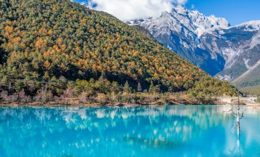 Autumn scene at Blue Moon Valley with clear blue lake and golden trees at Jade Dragon Snow Mountain, Lijiang, Yunnan