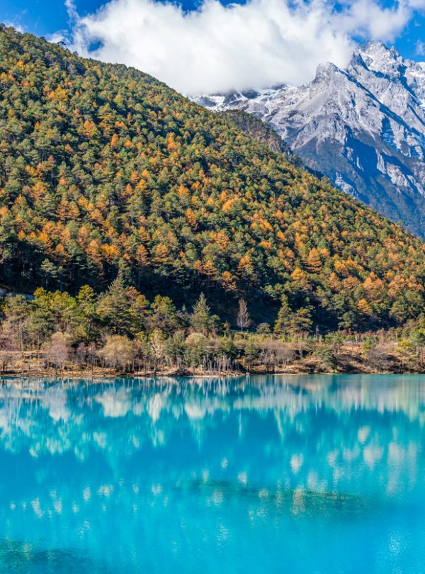 Autumn scene at Blue Moon Valley with clear blue lake and golden trees at Jade Dragon Snow Mountain, Lijiang, Yunnan