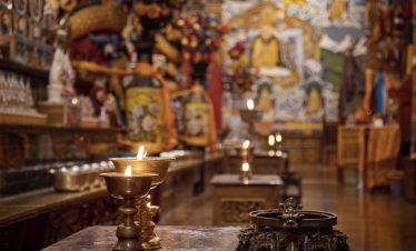 Interior details of Songzanlin Monastery including candle holders, murals, and Tibetan decorations
