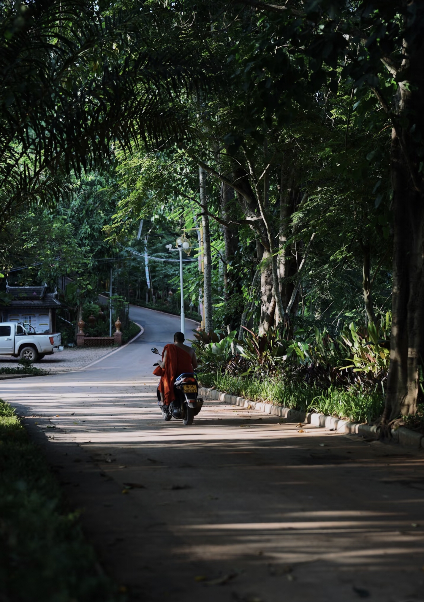Local resident riding motorbike on country road in Manyuan Village Xishuangbanna Yunnan