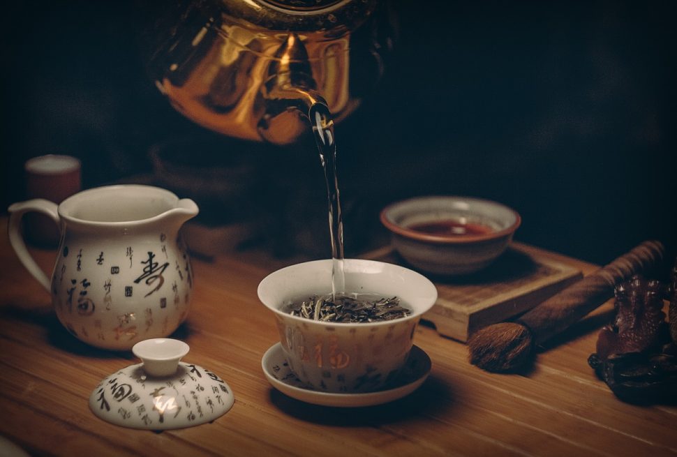 Pouring freshly brewed Pu-erh tea into a small tasting cup