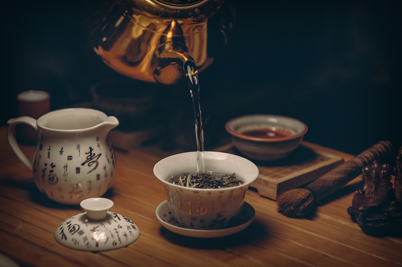 Pouring freshly brewed Pu-erh tea into a small tasting cup