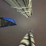 A view from below of the three iconic skyscrapers in Shanghai, China, towering into the sky.