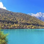 Indigo blue lake at Blue Moon Valley, Yunnan, China, with snow-capped mountains in the distance.