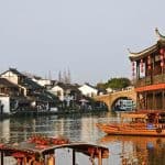 The picturesque scene of ZhuJiaJiao Water Town, Shanghai,China, with black rooftops, white walls, and red floating boats.