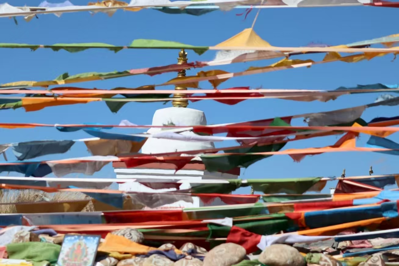 Colorful prayer flags with Jiwu Monastery in the background