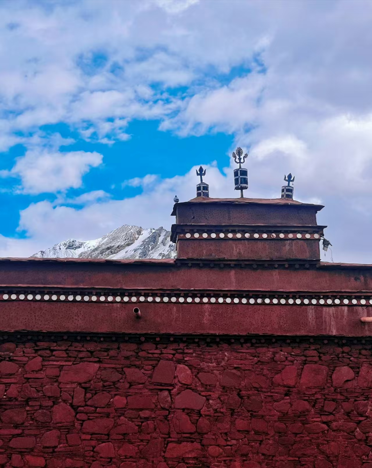 Roof of Serelong Monastery with snowy mountains in the background