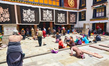 Devotee praying outside Jokhang Temple in Tibet