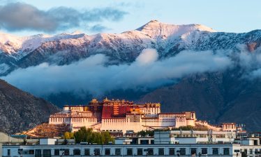 Sacred Potala Palace at the foot of snow mountains in Tibet