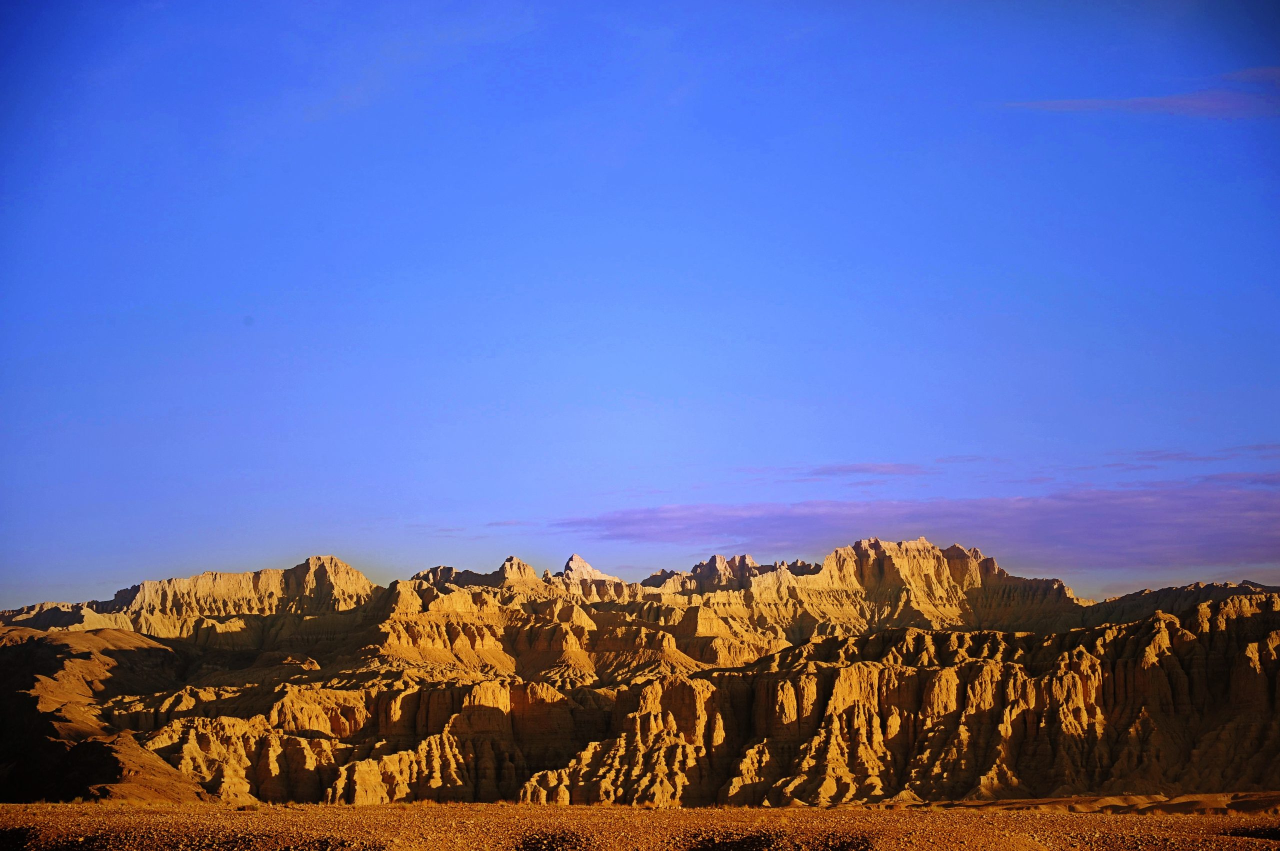 Yellow cliffs of Zanda Earth Forest under blue sky in Tibet