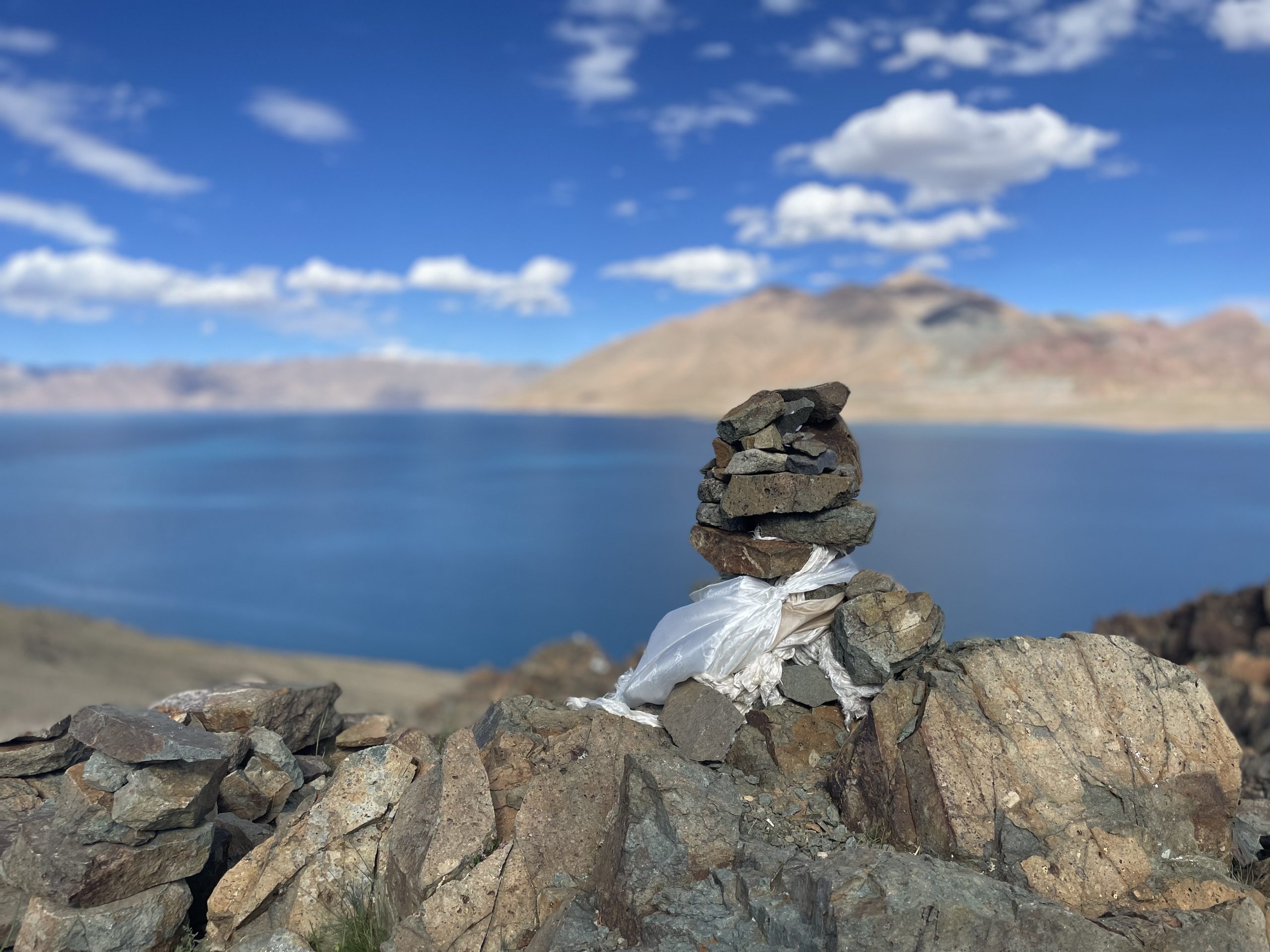 Lake Manasarovar view behind a pile of stones in Tibet