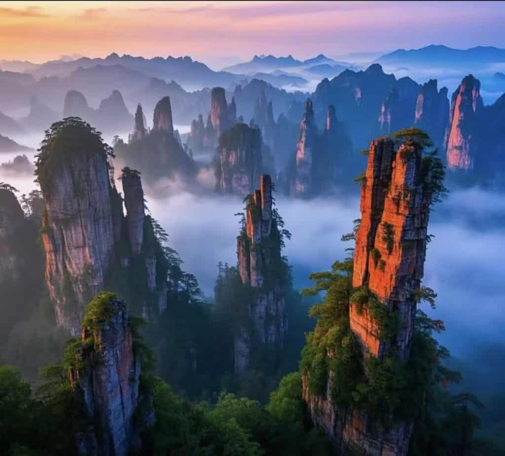 Warm orange sunset blending with green trees and blue sky over Zhangjiajie in Hunan, China