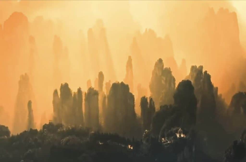 Golden sunset light casting a soft, mysterious glow over the peaks of Zhangjiajie National Forest Park in Hunan, China